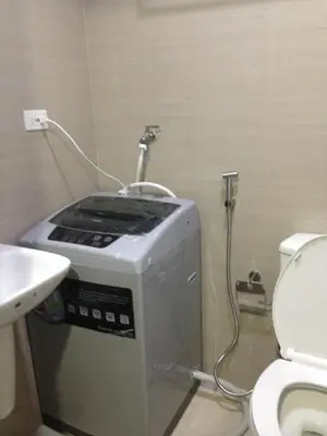 a washing machine in a bathroom next to a toilet at Shore Residences MOA in Manila