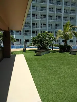 a large apartment building with a grassy yard with benches at Shore Residences MOA in Manila