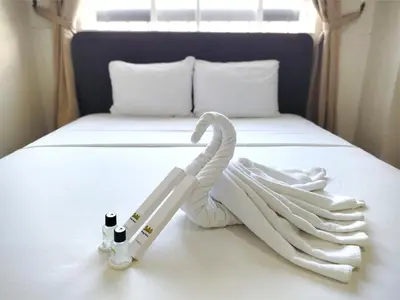 a bed with a towel and two bottles on it at Sulit Budget Hotel VMapa in Manila
