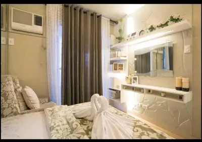a bedroom with a bed and a mirror and a television at Sta.Mesa across SM Model Unit 2 BR in Manila