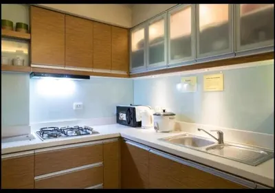 a kitchen with a sink and a stove and a microwave at Sta.Mesa across SM Model Unit 2 BR in Manila