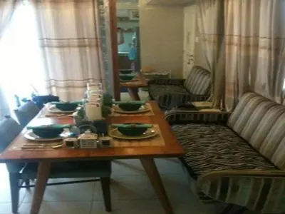 a living room with a wooden table and a couch at Sta.Mesa across SM Model Unit 2 BR in Manila