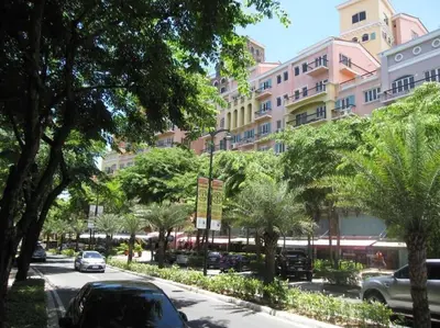 a street with cars parked in front of a large building at Condotel Type in Manila