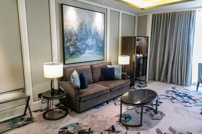 a living room with a couch and tables in a hotel room at Hotel Okura Manila at Newport World Resorts in Manila