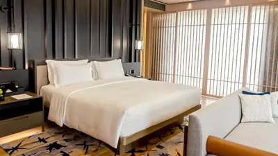 a bedroom with a large white bed and a couch at Hotel Okura Manila at Newport World Resorts in Manila