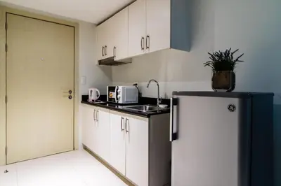 a kitchen with a sink and a refrigerator at Condotel @JAZZ Residences in Manila