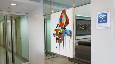 a large colorful painting on a wall in a room at Condotel @JAZZ Residences in Manila
