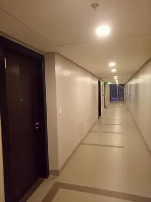an empty hallway with a black door in a building at Eighty One Newport Boulevard in Manila