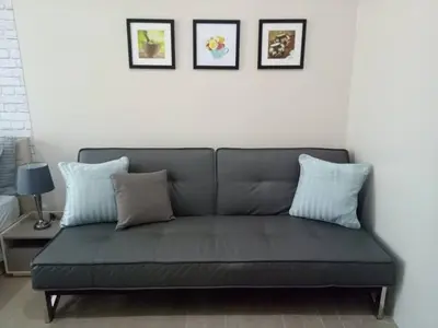 a couch in a living room with two pillows at Eighty One Newport Boulevard in Manila