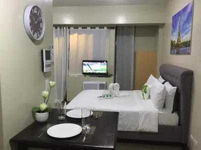 a hotel room with a bed and a table with plates on it at Palm Tree Villas 2 in Manila
