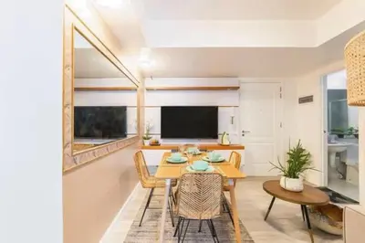 a dining room with a table and chairs and a television at Adam'sCrib Apartment 2BR by Azure Residences Near Manila International Airport in Manila