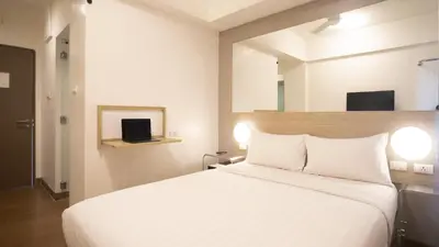 a bedroom with a large white bed and a mirror at Red Planet Makati Avenue Manila in Manila