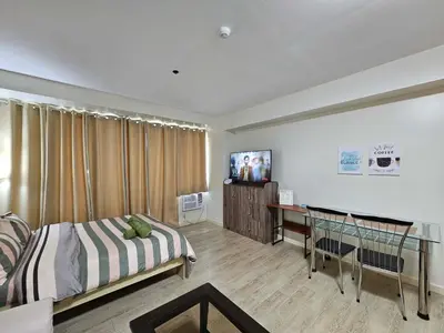 a bedroom with a bed and a desk in it at N place at Soho Central in Manila