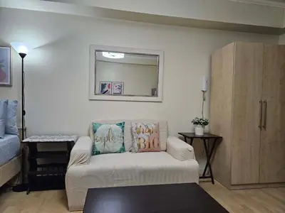 a living room with a couch and a mirror at N place at Soho Central in Manila