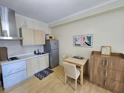 a small kitchen with a table and a refrigerator at N place at Soho Central in Manila