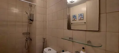 a bathroom with a shower and a toilet and a mirror at N place at Soho Central in Manila