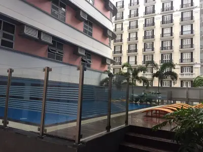 a fence next to a building with a swimming pool at 101 Newport City near NAIA 3, Pasay City in Manila