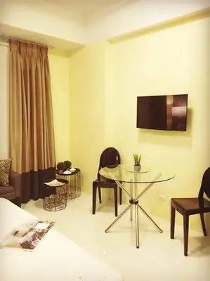 a living room with a glass table and chairs at 101 Newport City near NAIA 3, Pasay City in Manila