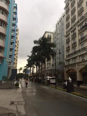 an empty city street with palm trees and buildings at 101 Newport City near NAIA 3, Pasay City in Manila