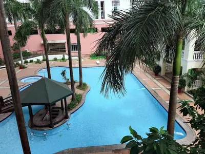 an overhead view of a swimming pool with palm trees at Affordable 2 BR 2 BA w/ Skycable, Netflix, & Amazon Prime in Manila
