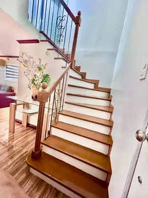 a staircase in a house with a vase of flowers at Affordable 2 BR 2 BA w/ Skycable, Netflix, & Amazon Prime in Manila