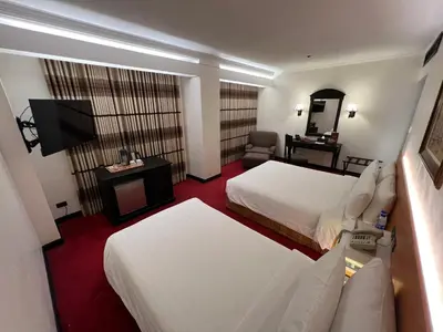 a hotel room with two beds and a television at Bayview Park Hotel Manila in Manila