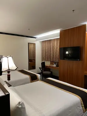 a hotel room with two beds and a flat screen tv at Bayview Park Hotel Manila in Manila