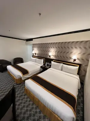 a hotel room with two beds and a couch at Bayview Park Hotel Manila in Manila