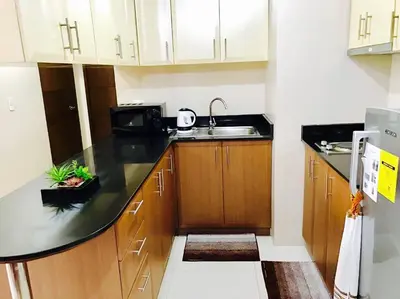 a small kitchen with a sink and a microwave at Resorts World Condo in Manila