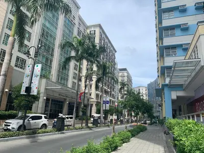 a city street with palm trees and buildings at Resorts World Condo in Manila