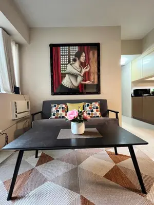 a living room with a coffee table and a painting at Resorts World Condo in Manila