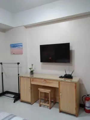 a room with a desk with a television on a wall at 101 Newport Boulevard C1 in Manila