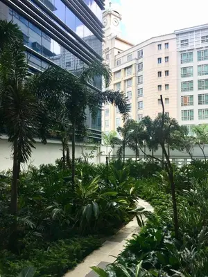 a garden with a clock tower in a city at 101 Newport Boulevard C1 in Manila