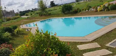 a large swimming pool in a yard with a hill at Julzhome PH Properties by Juliet AfricaPervaze in Santa Rosa