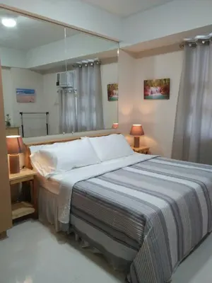 a bedroom with a large bed with a large mirror at 101 Newport Blvd Condotel in Manila