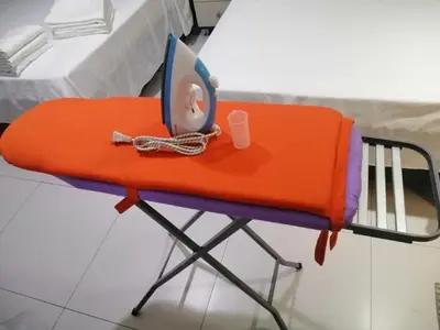 a bed with an orange cushion and a table at KL Tower Makati Apartments by PH Staycation in Manila