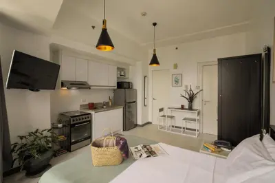 a living room with a kitchen with a table at KL Tower Makati Apartments by PH Staycation in Manila
