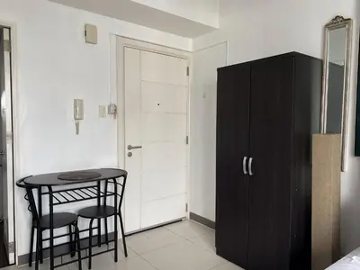 a room with a table and two chairs and a cabinet at KL Tower Makati Apartments by PH Staycation in Manila