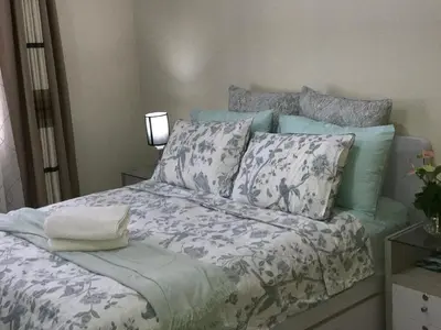 a bed with blue and white sheets and pillows at Chillax Studio 101 Newport Boulevard in Manila