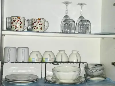 a shelf filled with dishes and glasses and plates at Chillax Studio 101 Newport Boulevard in Manila