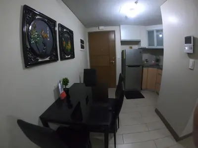 a kitchen and dining room with a black table and chairs at Palm Tree 2 Villas-Cluster 2 Unit 3N in Manila