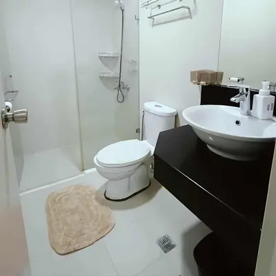 a white bathroom with a toilet and a sink at Two Palm Tree Villas close to Manila Airport - Terminal 3 in Manila