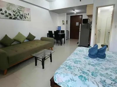 a room with a bed and a couch and a table at Two Palm Tree Villas close to Manila Airport - Terminal 3 in Manila