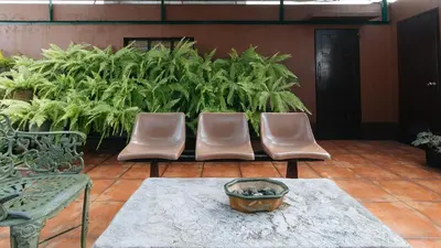 three chairs and a table in a room with plants at L Mansion 2 Palanan Makati City in Manila