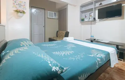 a bedroom with a bed with a blue blanket at L Mansion 2 Palanan Makati City in Manila
