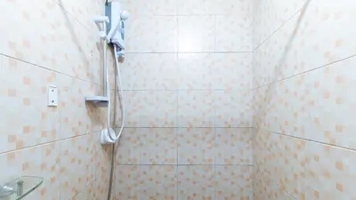 a shower in a bathroom with a tiled wall at L Mansion 2 Palanan Makati City in Manila