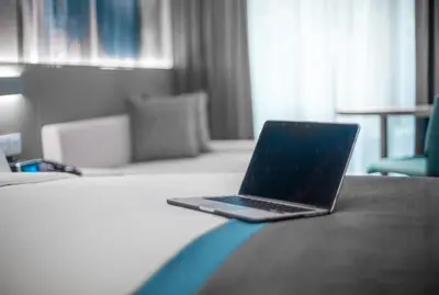 a laptop computer sitting on a bed in a hotel room at Holiday Inn Express Manila Newport City by IHG in Manila