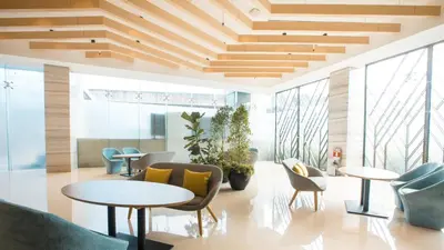a lobby with tables and chairs and windows at Holiday Inn Express Manila Newport City by IHG in Manila