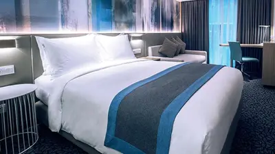 a hotel room with a large bed and a chair at Holiday Inn Express Manila Newport City by IHG in Manila