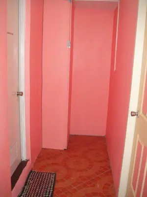 a hallway with pink walls and a red floor at JCP Room Rentals in Manila